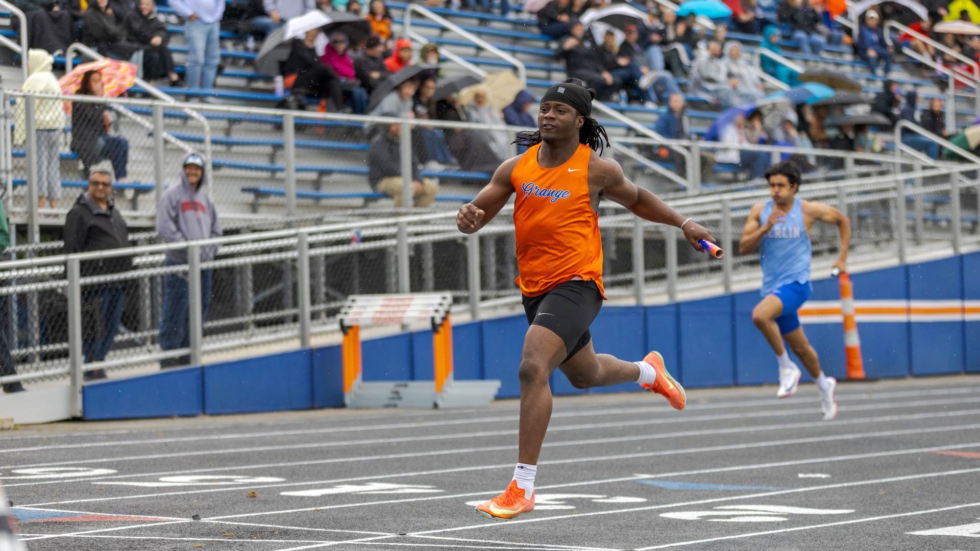 Sprinter finishing a relay leg at an Ohio high school track meet